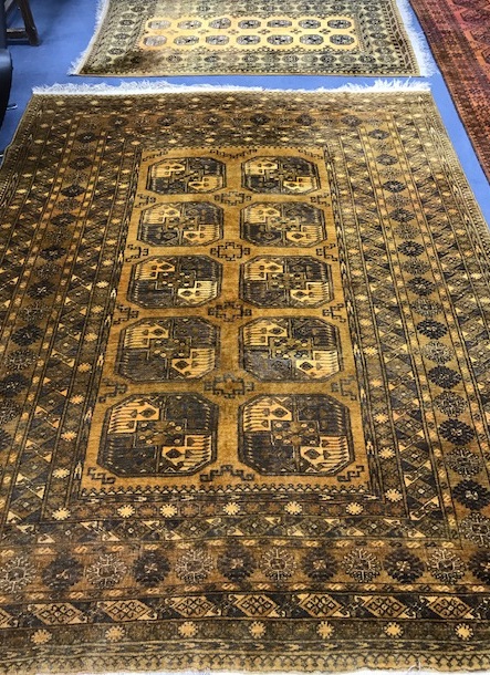 A Bokhara rust ground rug and a large carpet 280x170cm + 195 x 106cm